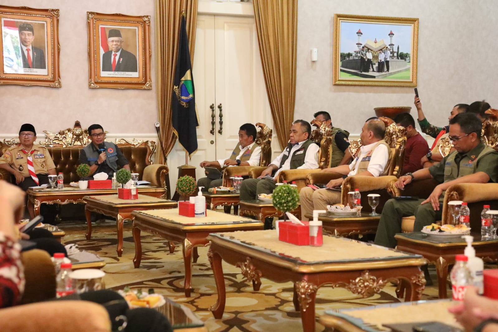 Kepala BNPB Letjen TNI Suharyanto (menggunakan rompi dan kemeja hijau) saat memimpin Rapat Evaluasi Percepatan Pelaksanaan Pembangunan Rumah Rusak bagi masyarakat terdampak gempa pada November yang lalu. Rapat ini dilaksanakan di Kantor Bupati Cianjur, Jawa Barat pada Jumat (14/7).